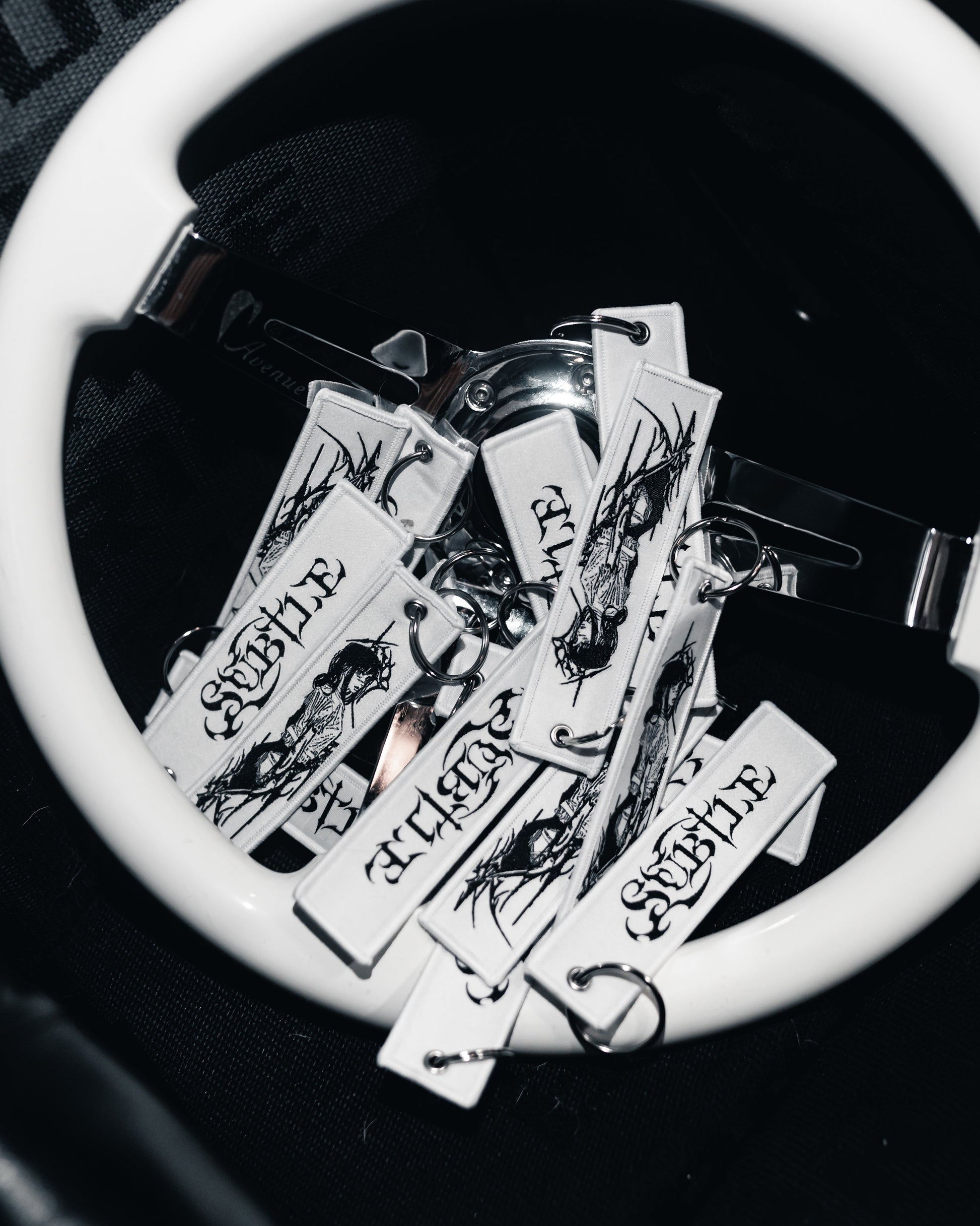 Collection of tattoo-style keychains on a white surface